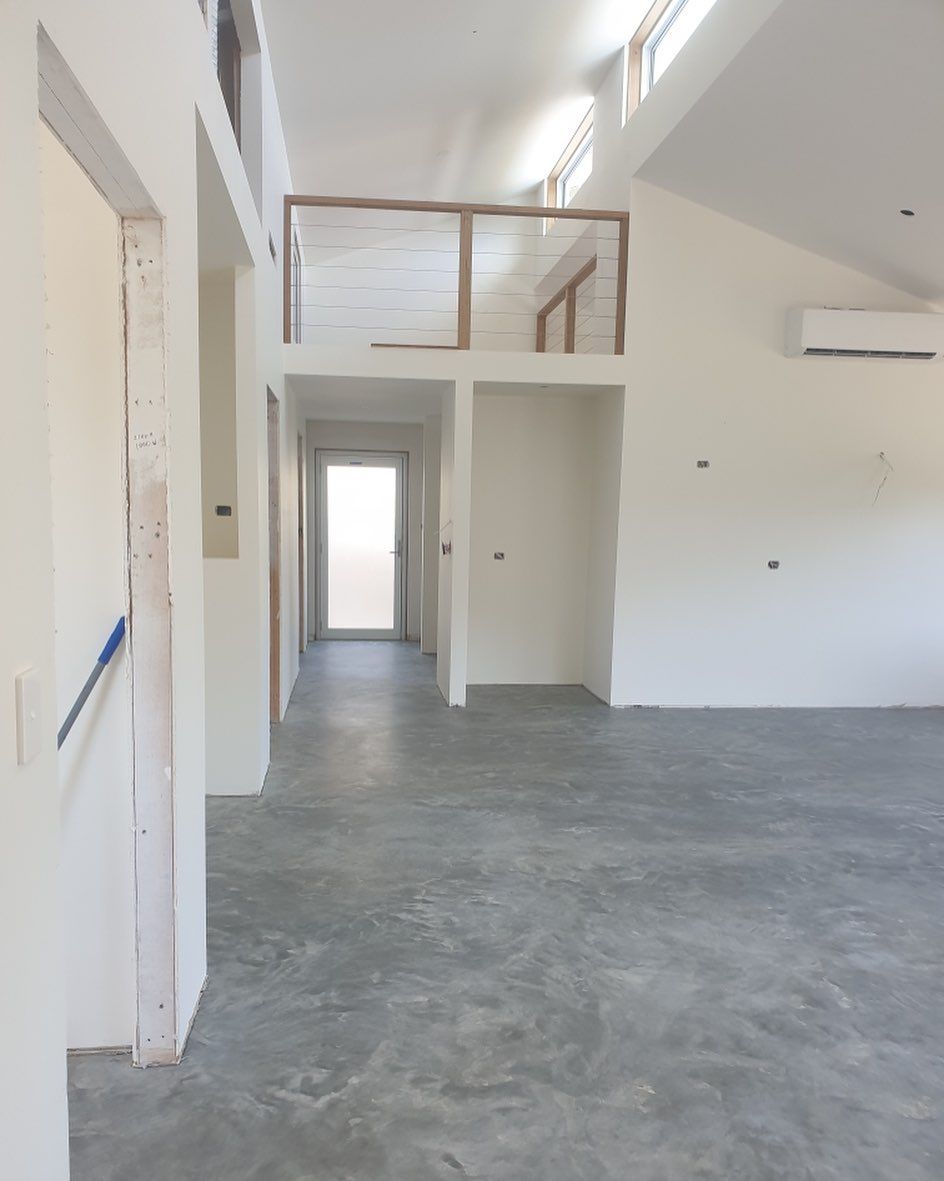 An empty room with a concrete floor and white walls