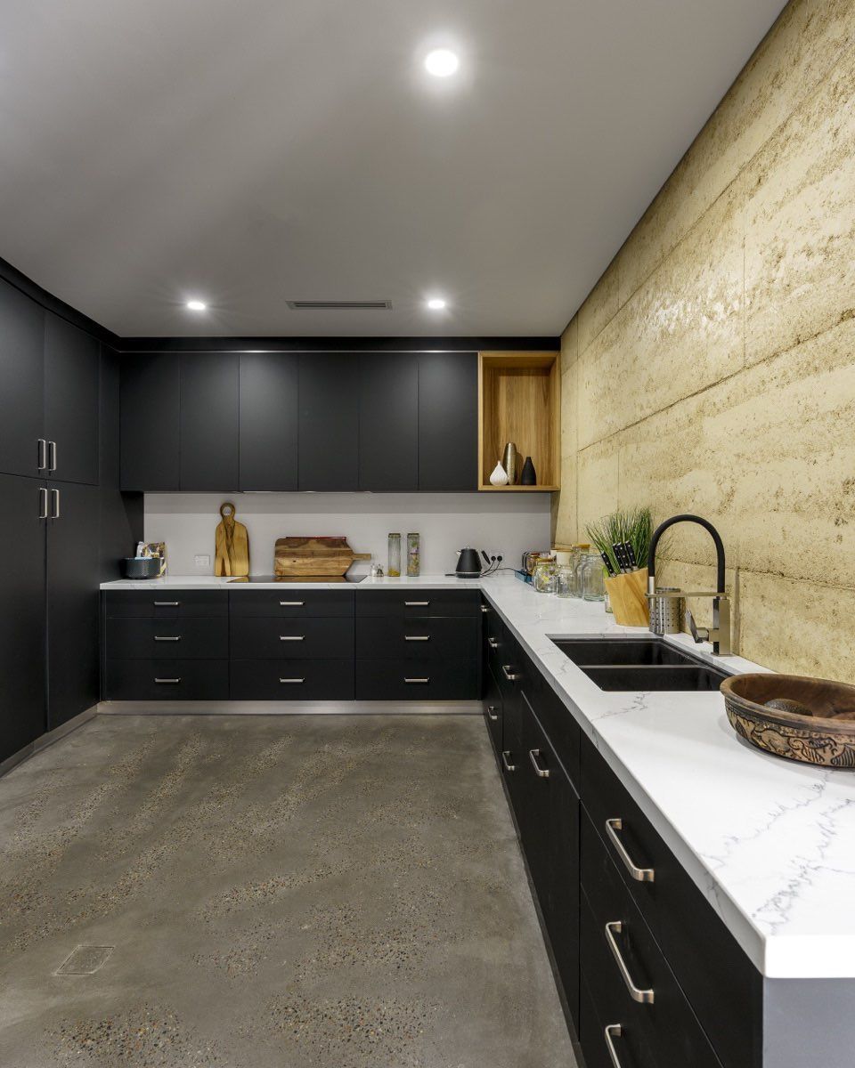 A kitchen with black cabinets and white counter tops