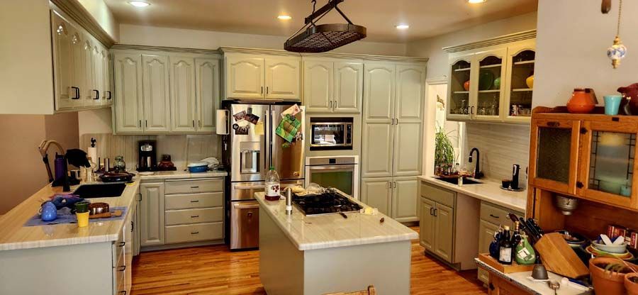 A kitchen with white cabinets and a large island in the middle.