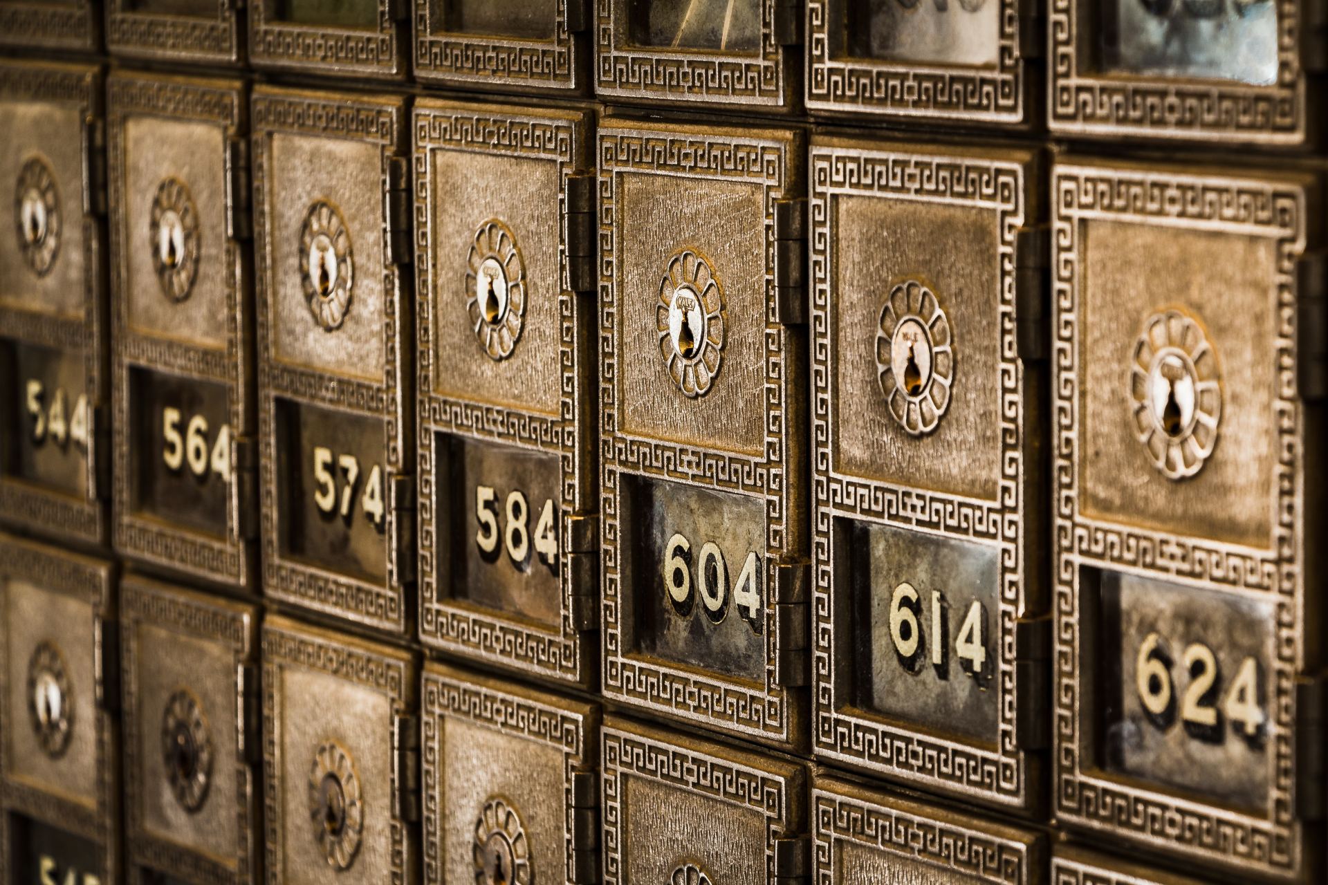 A row of safes with numbers on them are lined up on a wall.