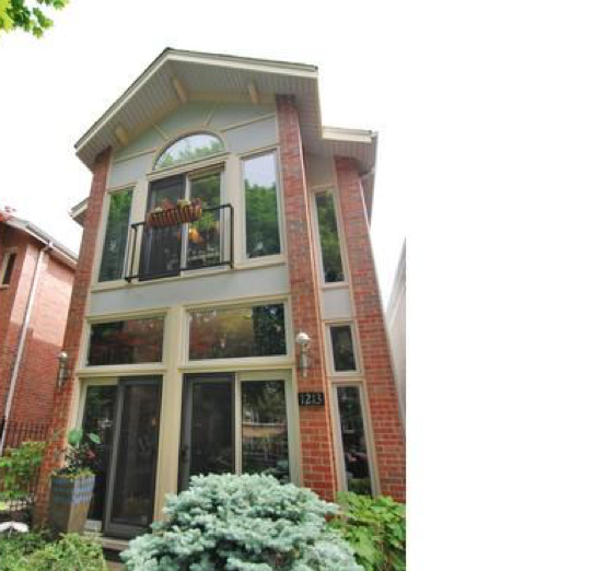 A large brick house with many windows and a balcony