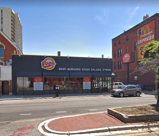 A pizza hut restaurant is located on the corner of a city street.