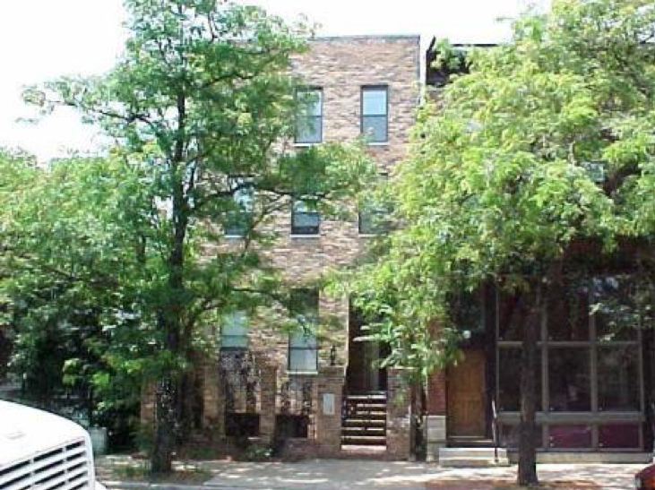 A white truck is parked in front of a brick building