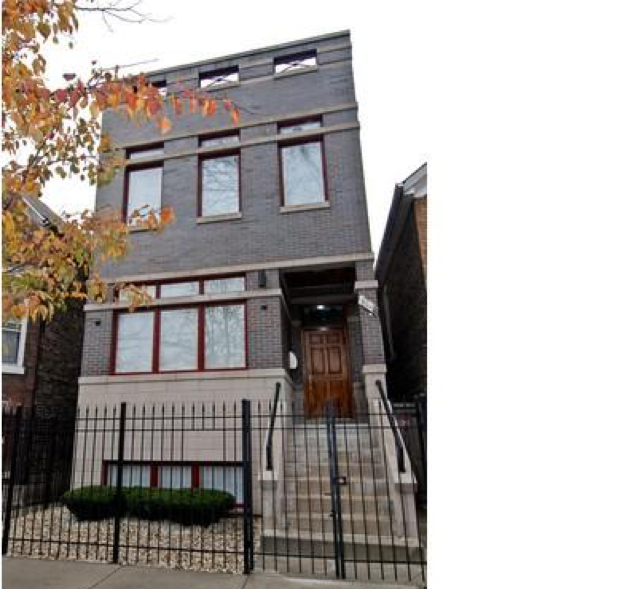 A brick building with stairs leading up to the front door