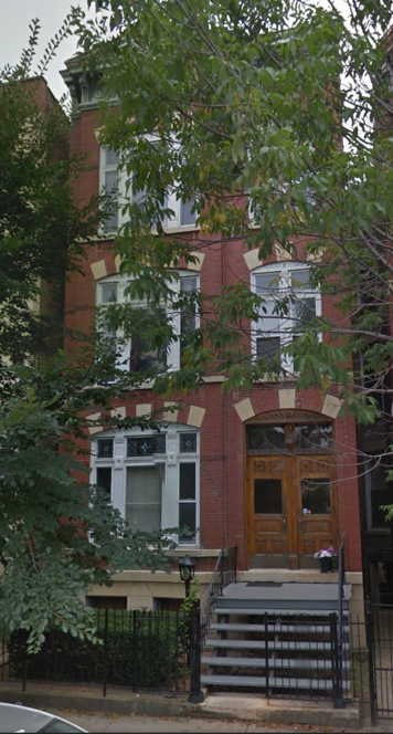 A large brick building with stairs leading up to the front door