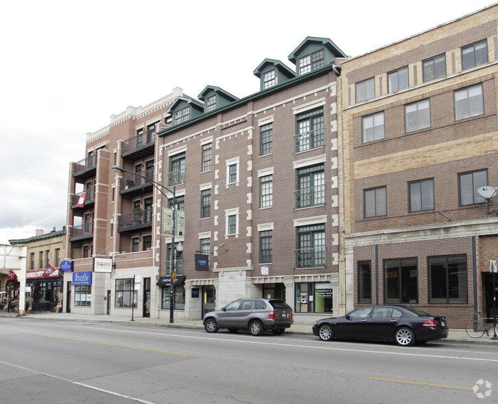 A row of buildings with cars parked in front of them