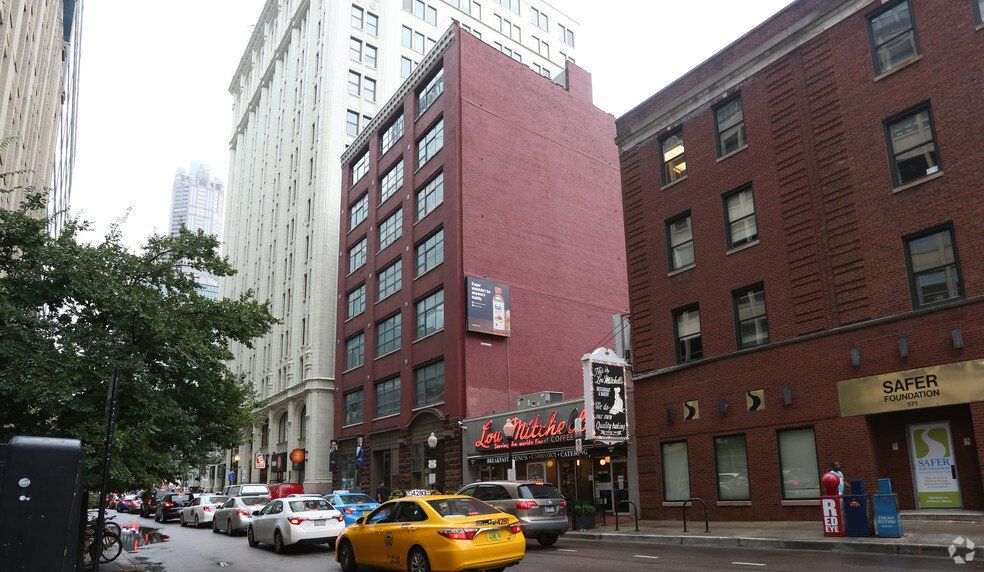 A yellow taxi is driving down a busy city street