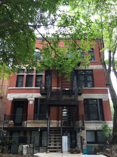 A large brick building with stairs leading up to the second floor