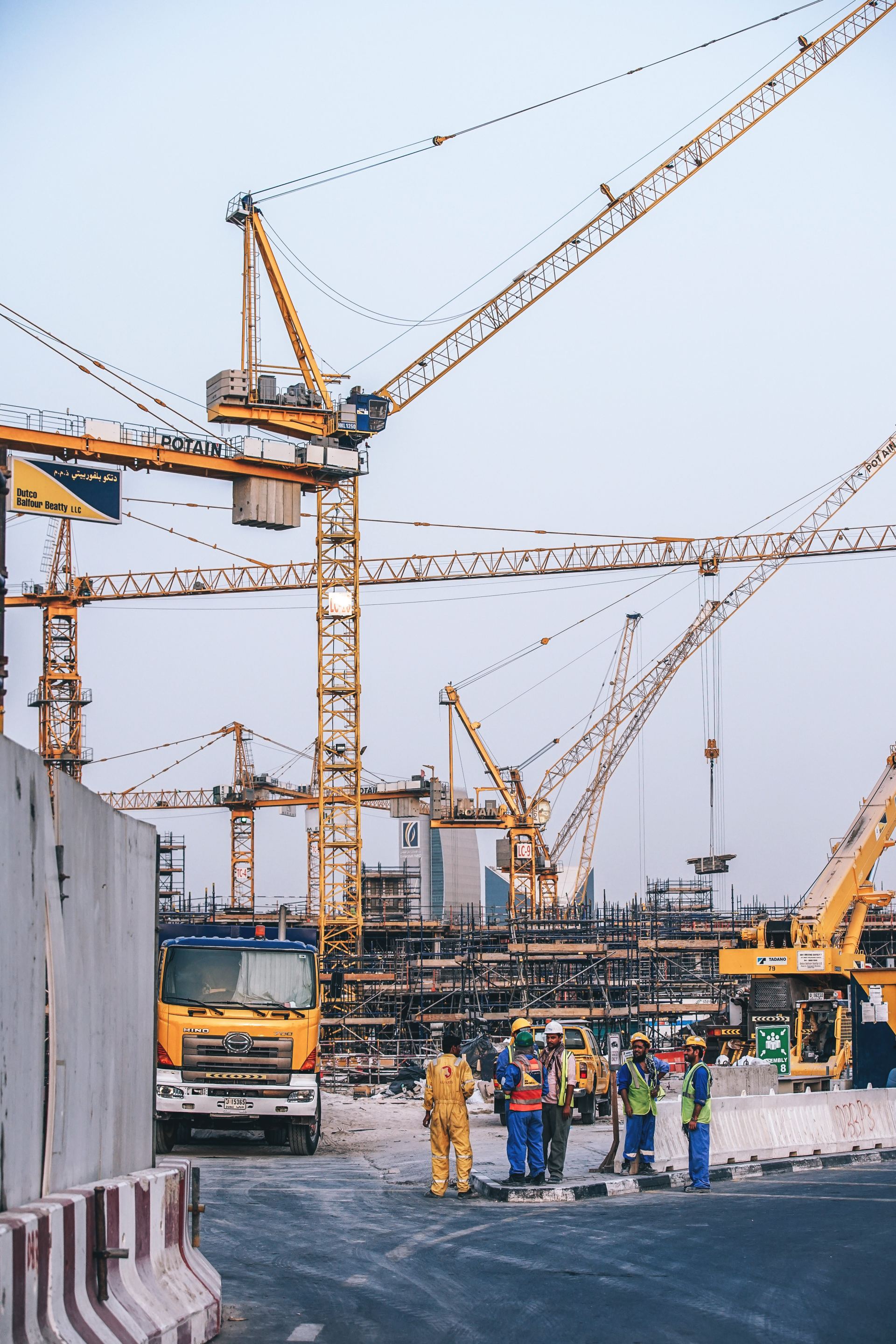 A group of construction workers are standing in front of a construction site.