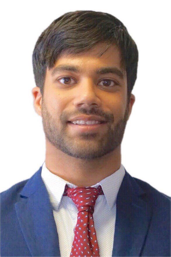 A man in a suit and tie is smiling for the camera