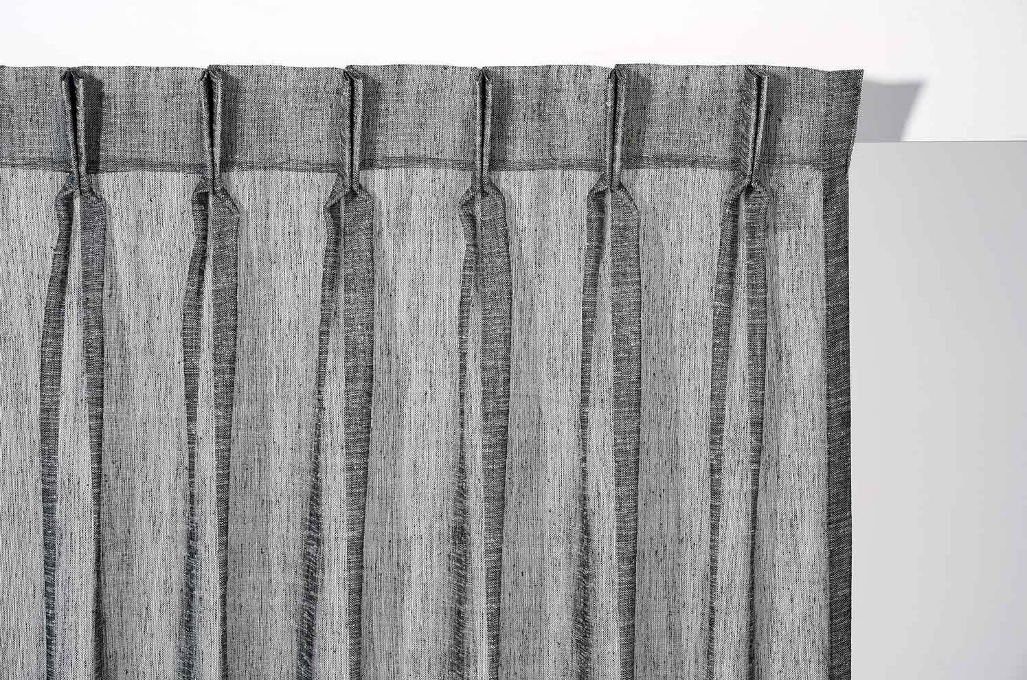 A plant is sitting in front of a window with blinds.