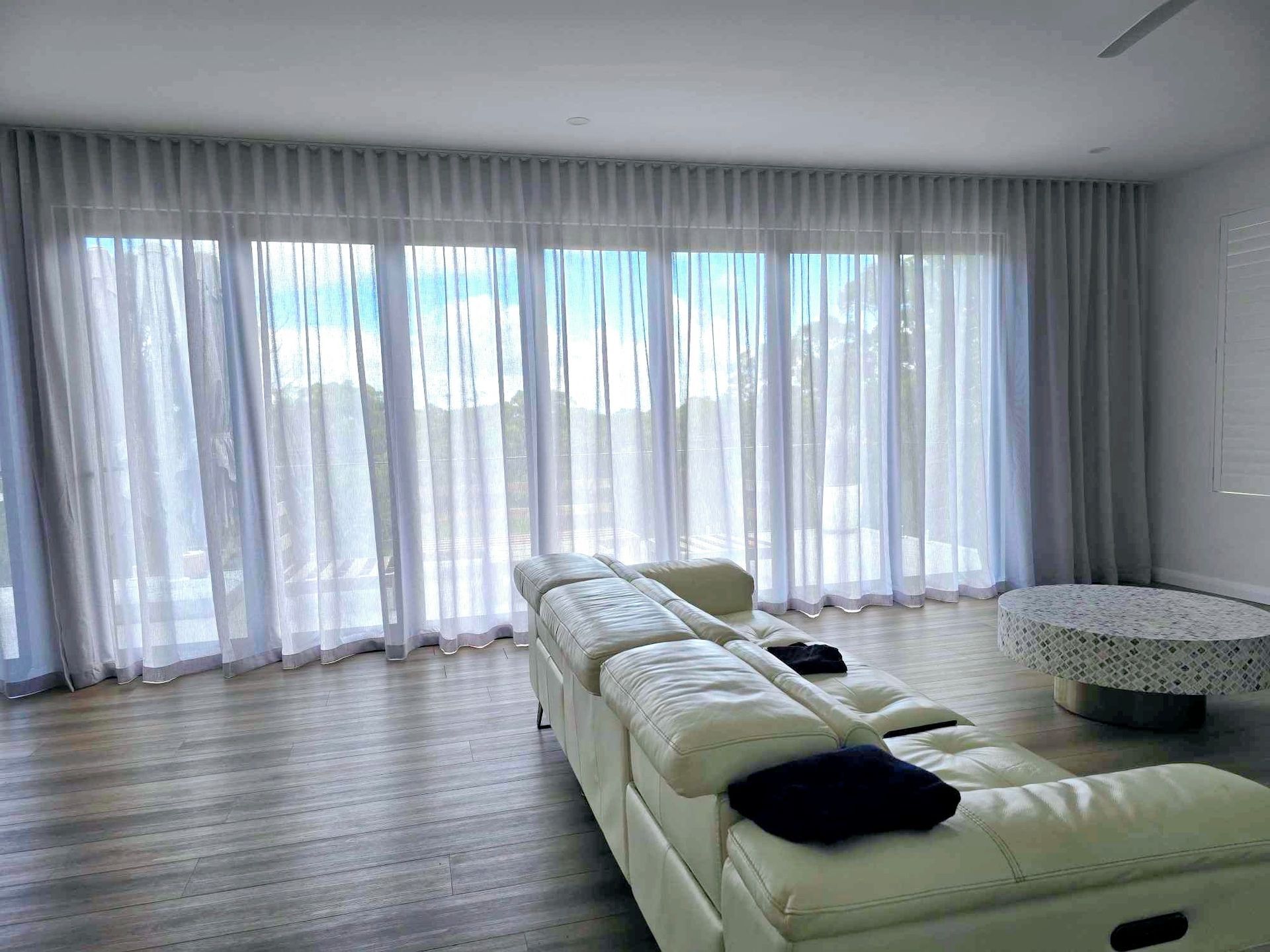 A living room with a white couch and a lot of windows.