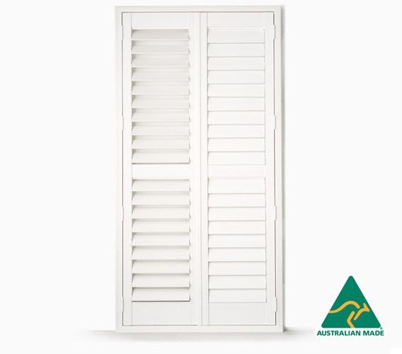 A bedroom with a bed and a chair with shutters on the windows