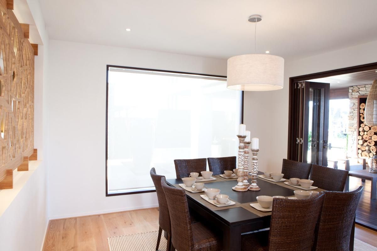 A dining room with a table and chairs and a large window