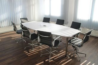 A conference room with a long table and chairs.