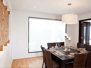 A dining room with a table and chairs and a large window