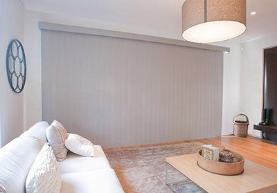 A living room with a couch , coffee table , and blinds.