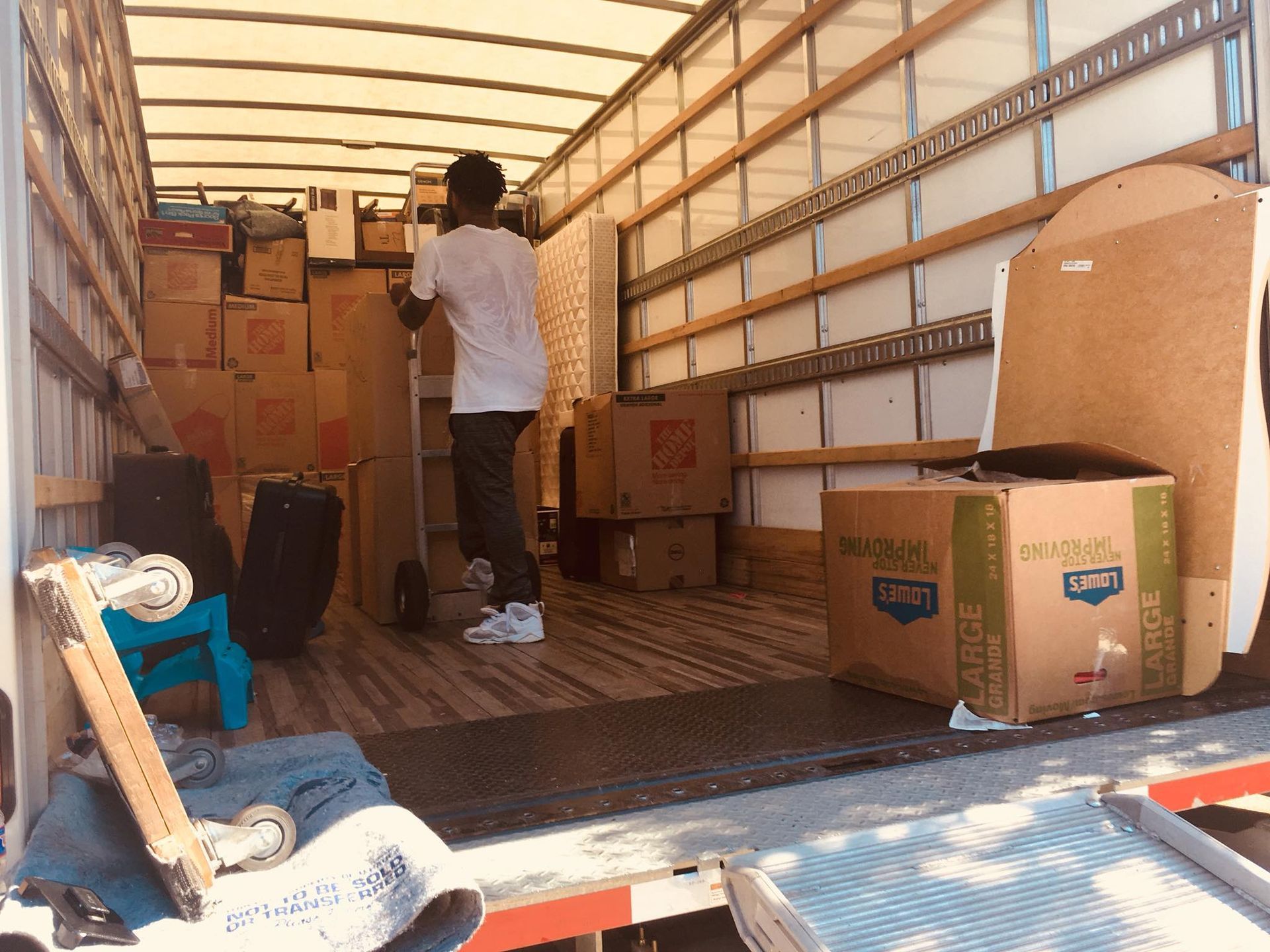 Man loading boxes into moving truck.