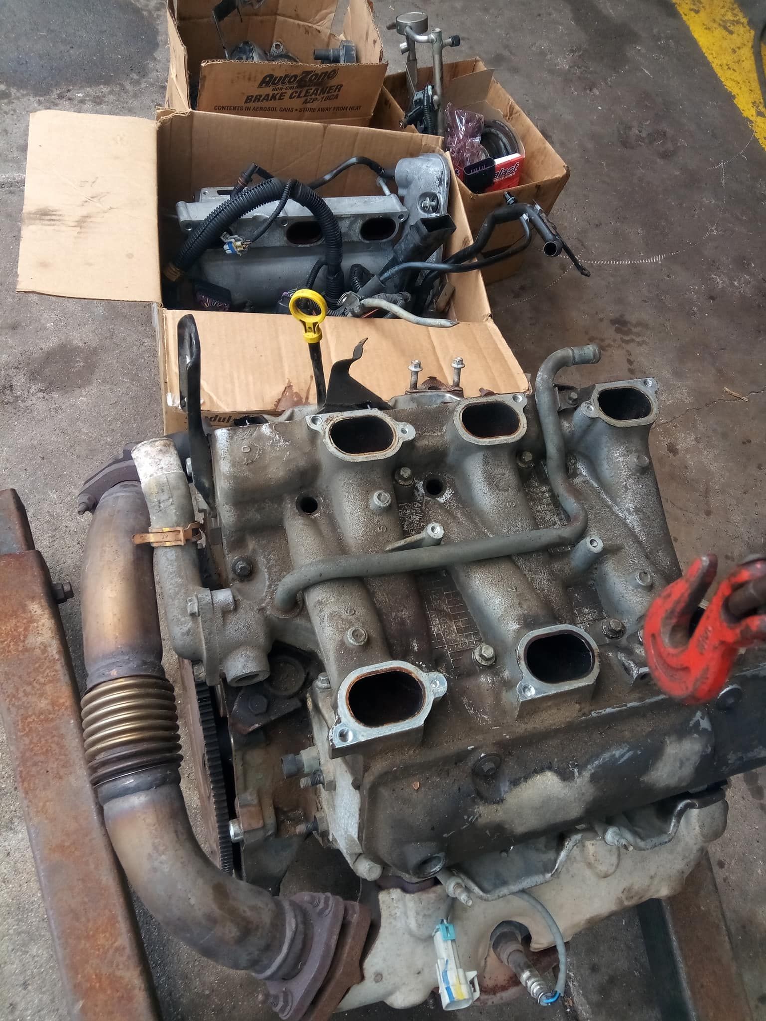 A broken engine sits next to boxes of parts