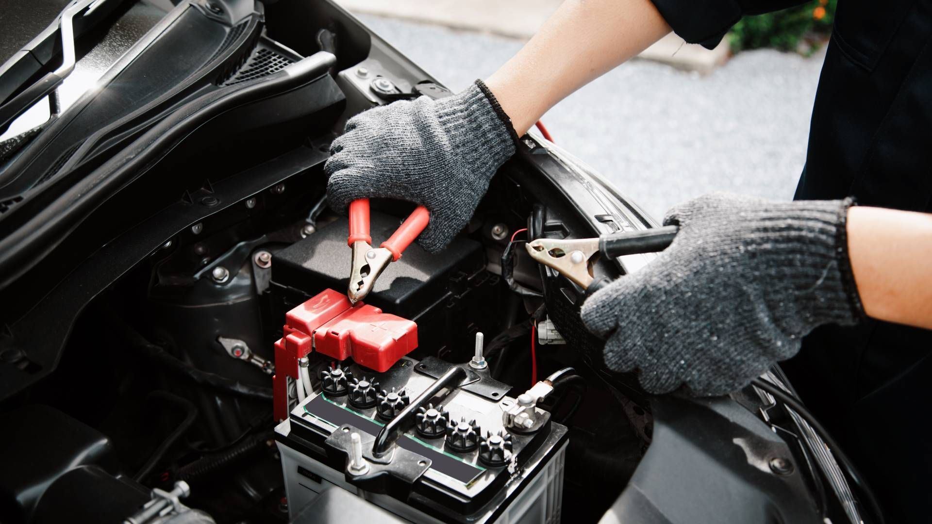 A person is charging a car battery with a charger.