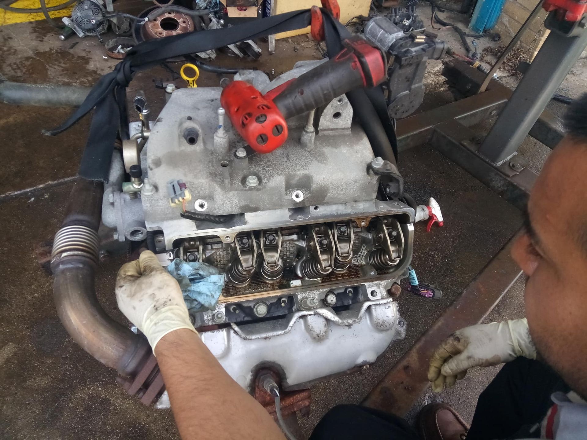 A man is working on a car engine in a garage