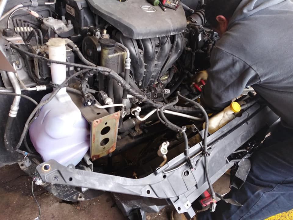 A man is working on the engine of a car