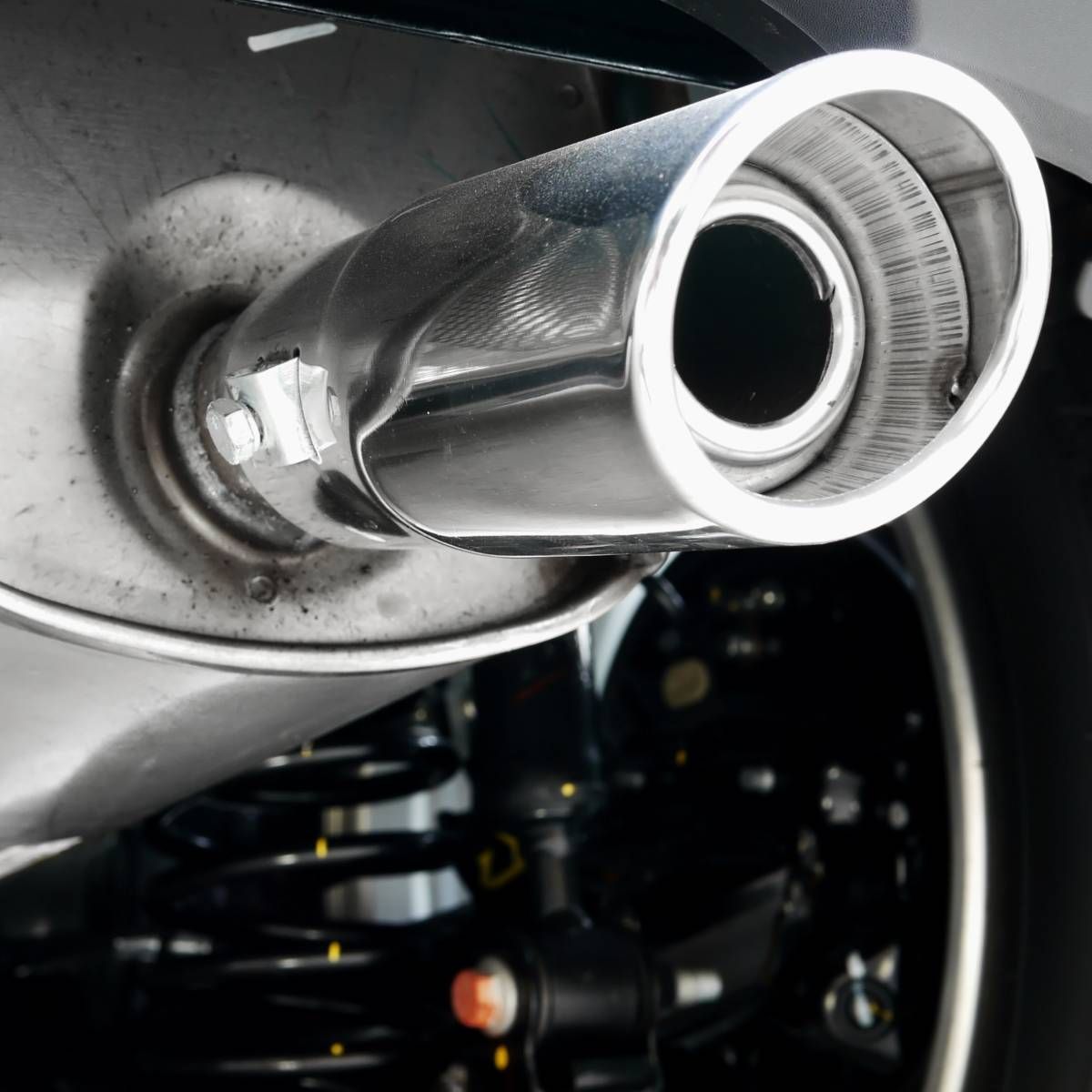 A close up of a stainless steel exhaust pipe on a car