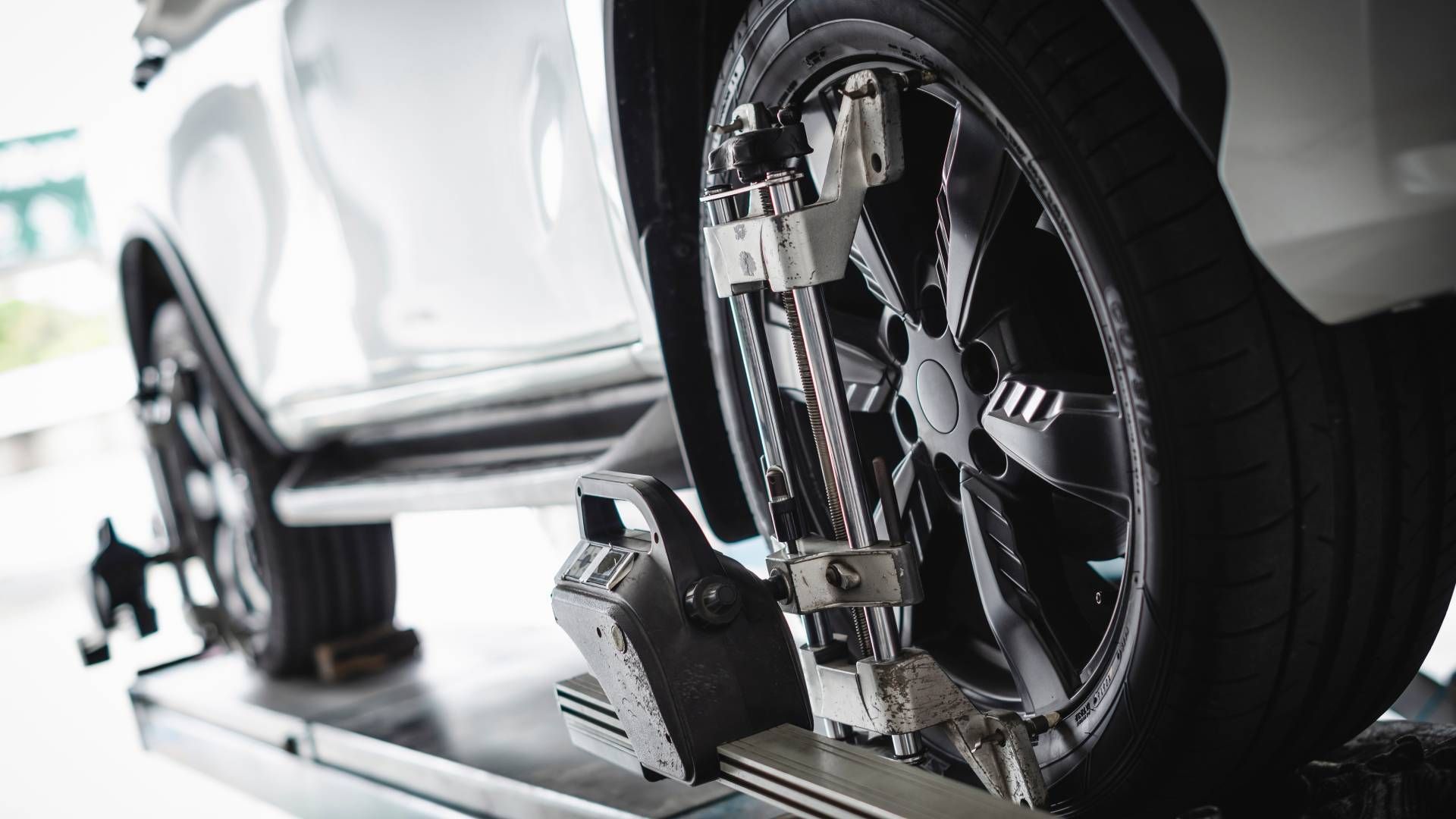 A car is being adjusted on a machine in a garage.