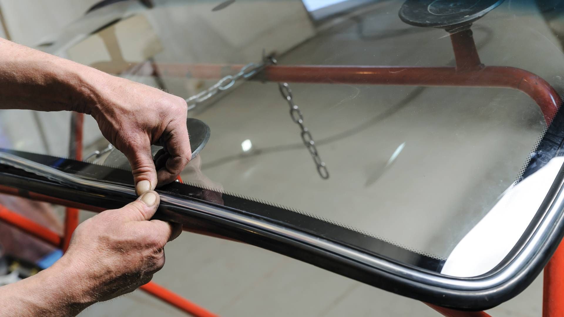 A person is fixing a windshield on a car.