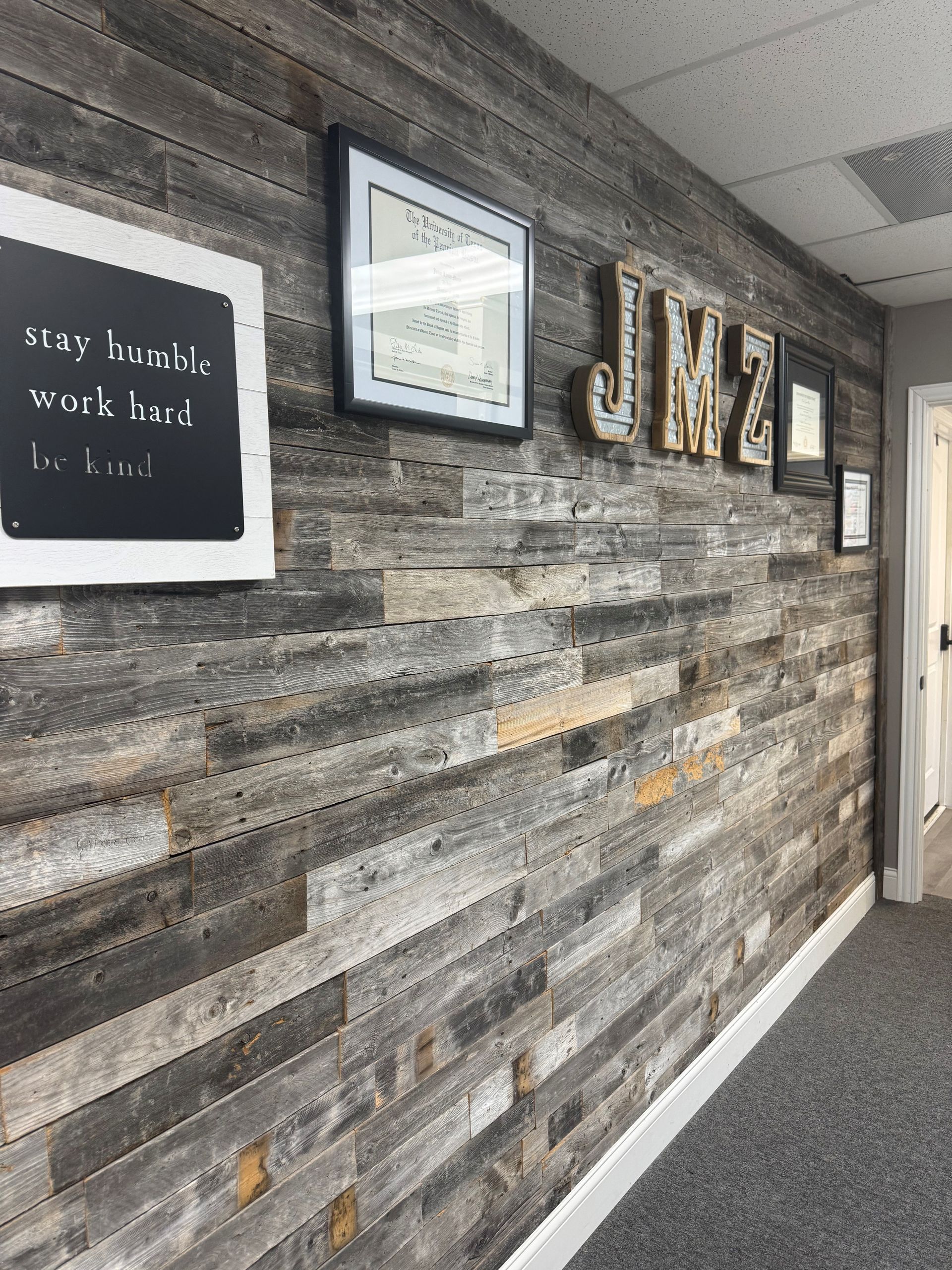 Wood-paneled wall with framed art and letters spelling 