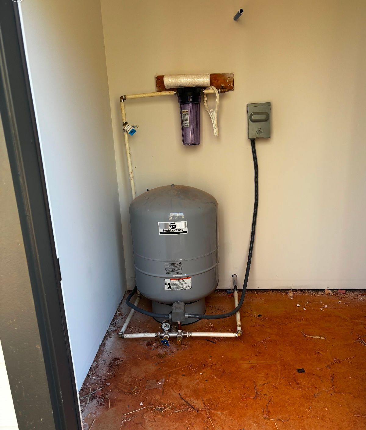A water tank is sitting in a room next to a wall.