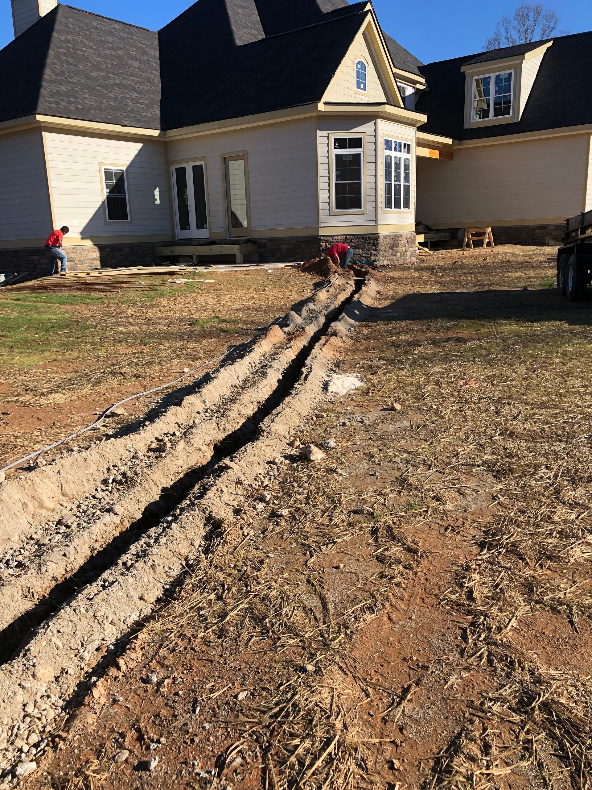 A water pump is sitting next to a well in a field.
