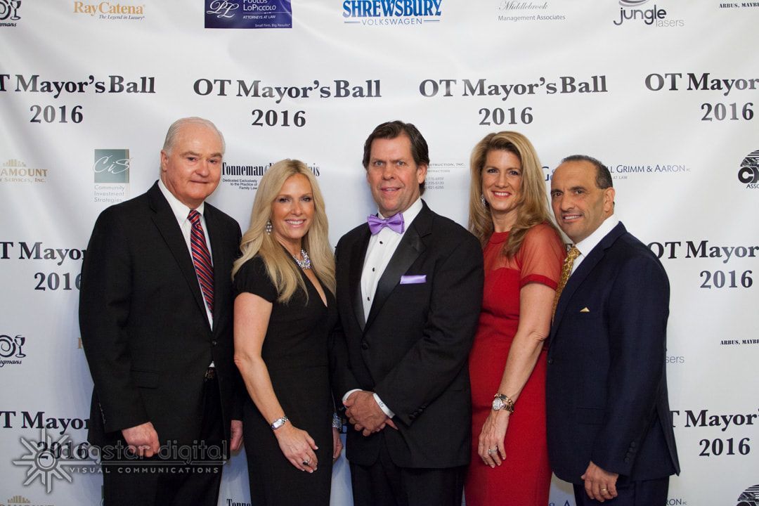 Five formally dressed people posing in front of a backdrop for the OT Mayor's Ball 2016.