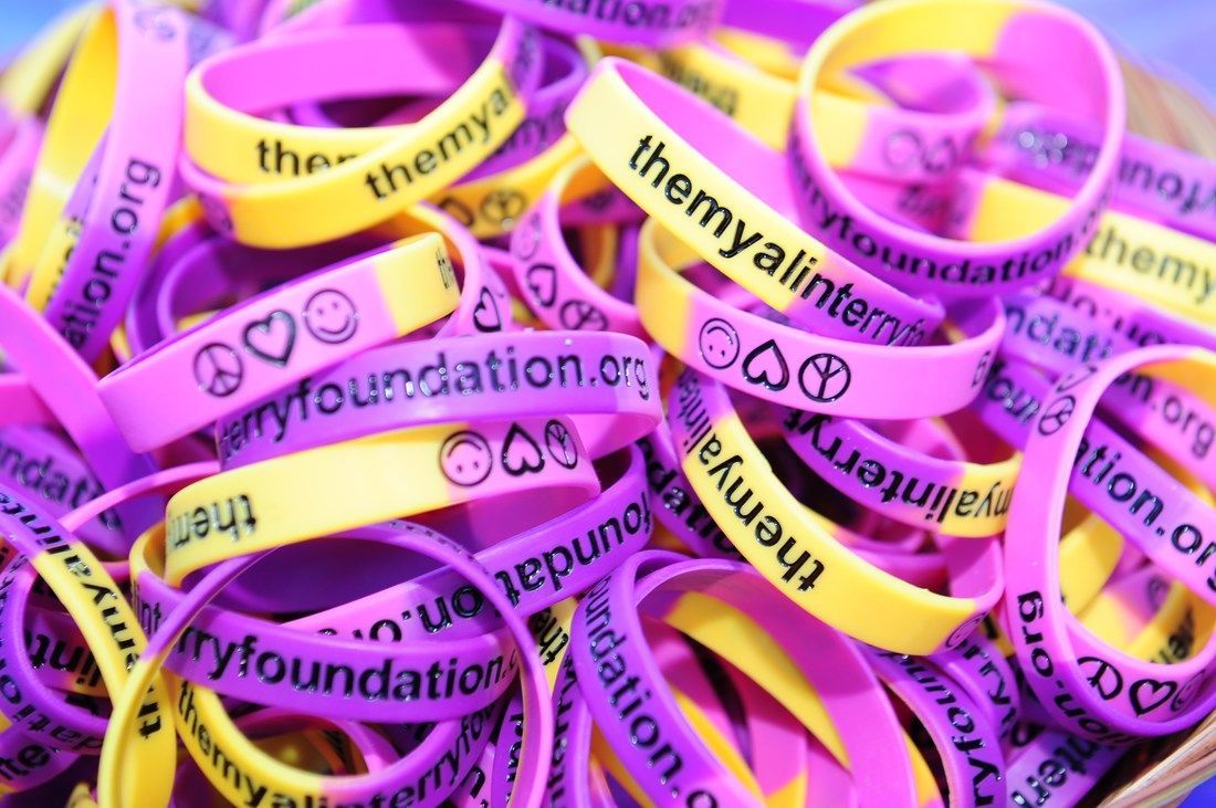 Pile of purple and yellow wristbands with 
