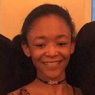 Smiling person wearing a black choker necklace with 