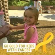 Young girl with a pink shirt smiles at a table with a 