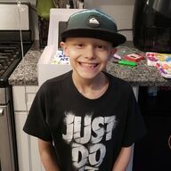 Boy wearing a green hat and a black 