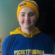 Person wearing a yellow Pitt beanie and blue sweatshirt that says 