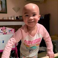 Smiling child with a bald head wearing a 