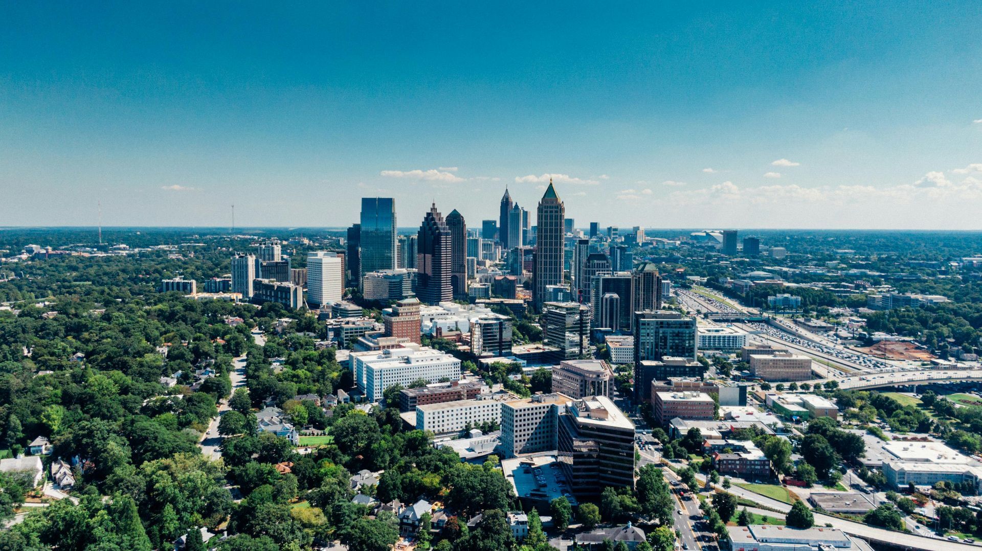 An aerial view of a city skyline surrounded by trees.
