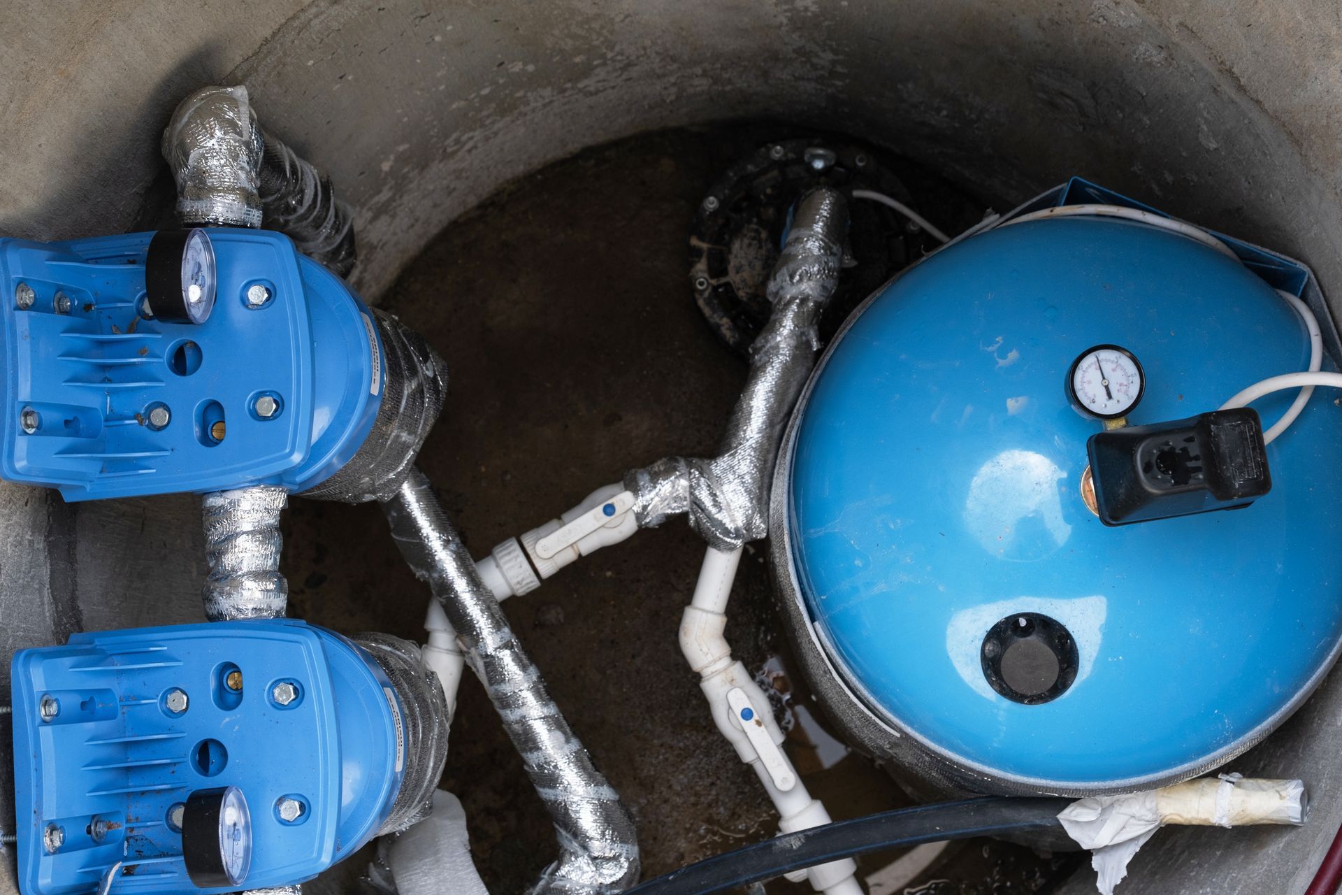 A water pump system setup inside a concrete enclosure.