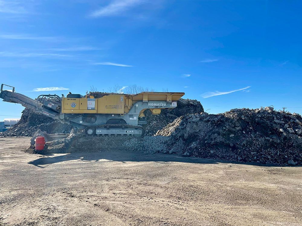 a large pile of dirt is being crushed by a machine .
