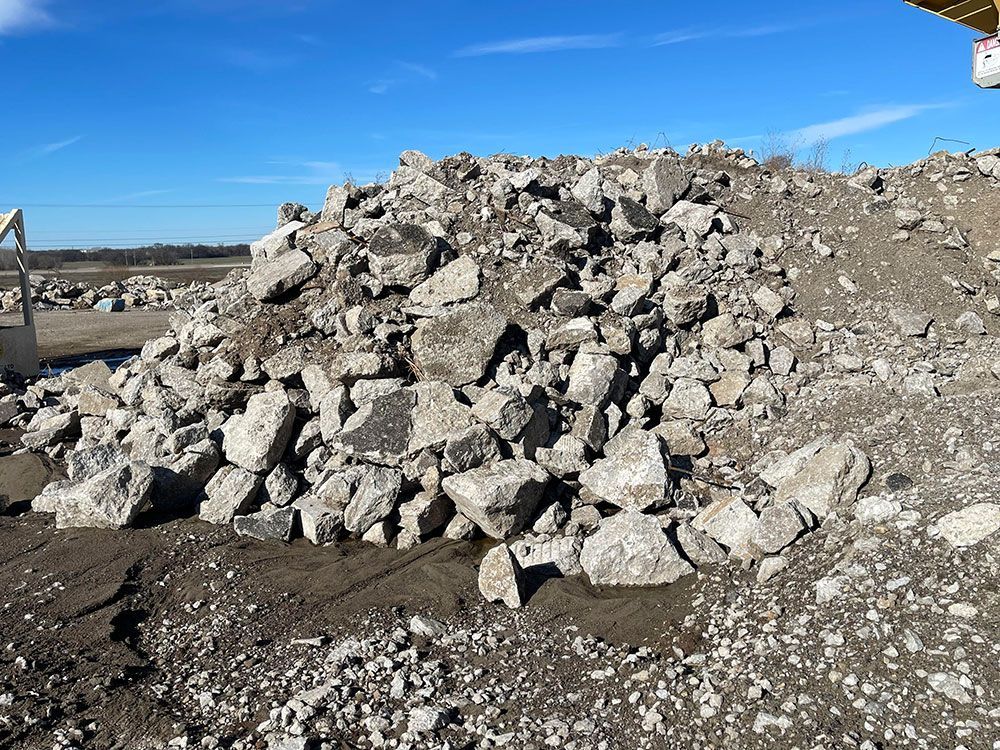 a pile of rocks is sitting on top of a dirt field .