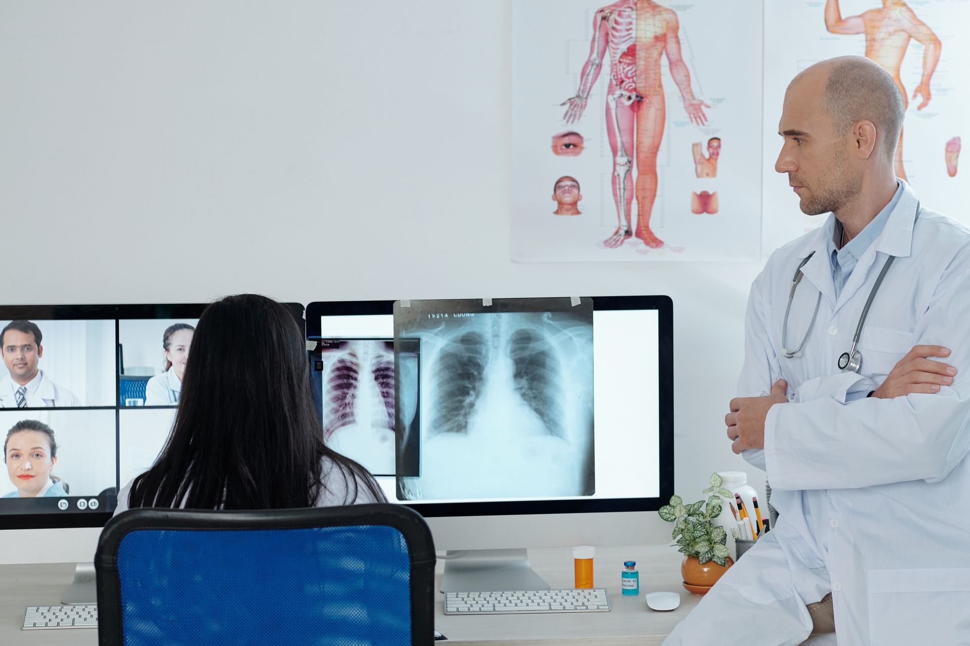 A doctor is talking to a patient on a video call while looking at an x-ray.