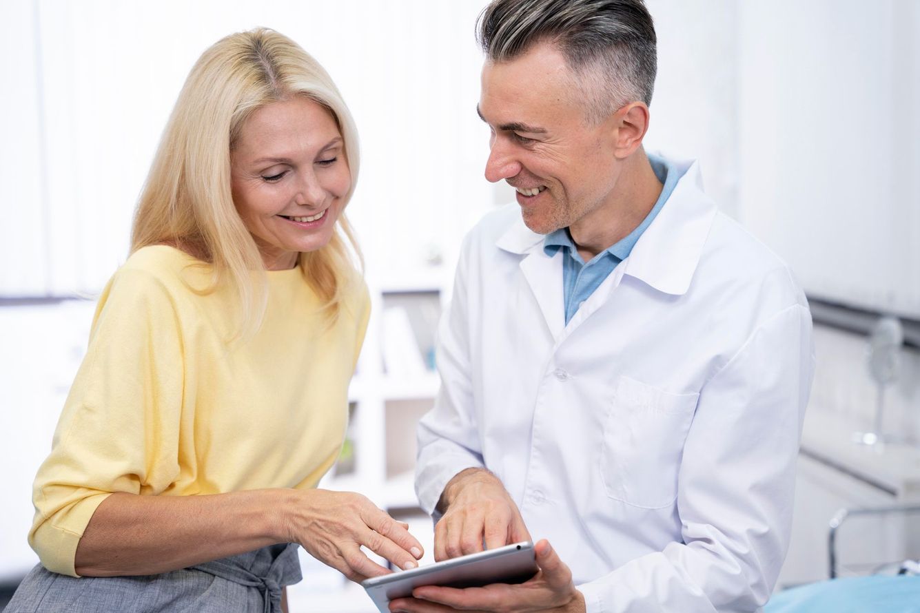 A man and a woman are looking at an x-ray in a hospital room.