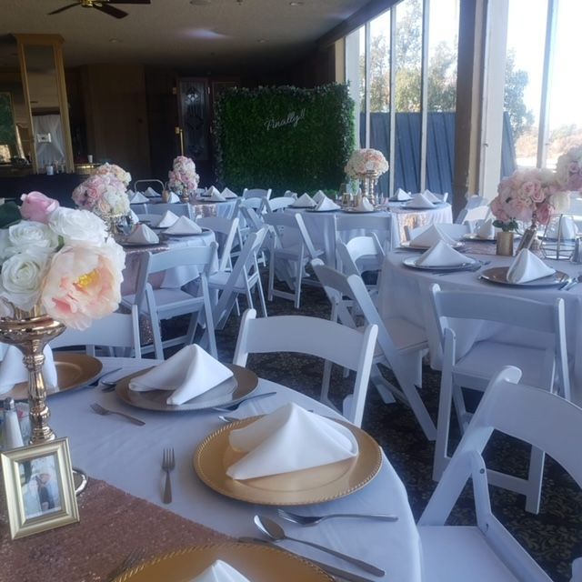 A room with tables and chairs set up for a wedding reception