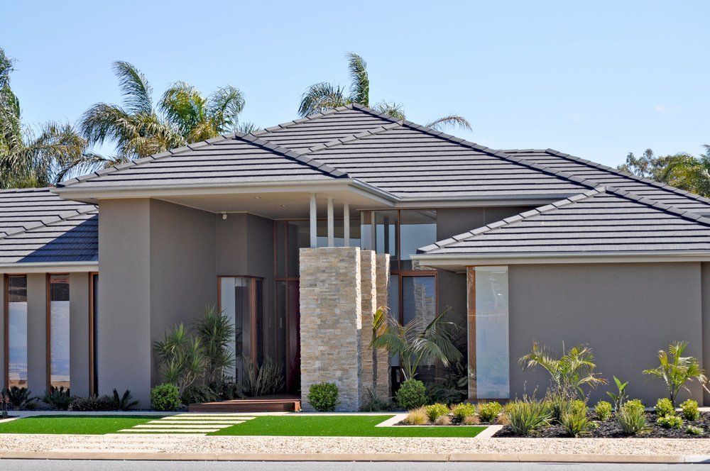 A Large House With A Tiled Roof Is Sitting On A Lush Green Lawn — Anytime Conveyancing In Wingham, NSW