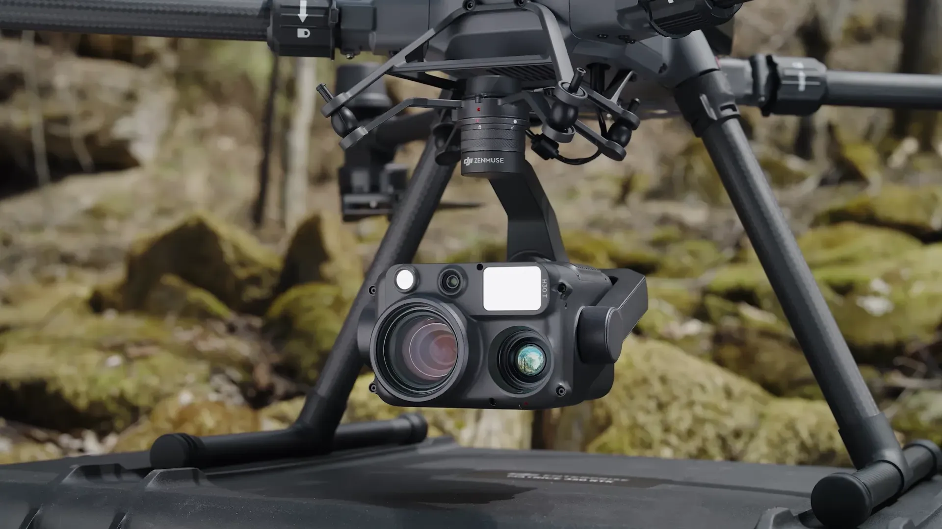 A drone with a camera attached to it is sitting on the ground.