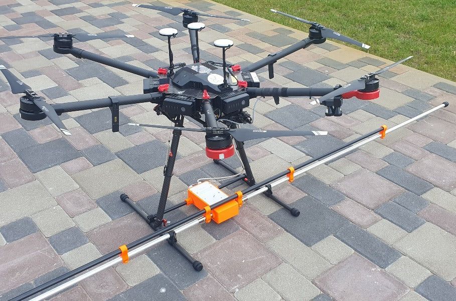 A drone with a camera attached to it is sitting on the ground.