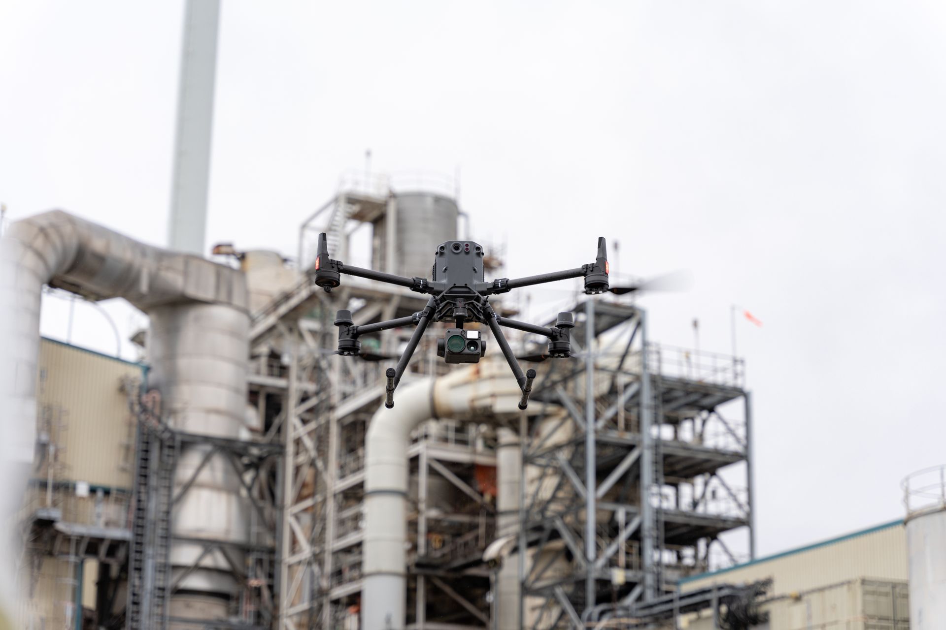 A drone is flying over a large industrial building.